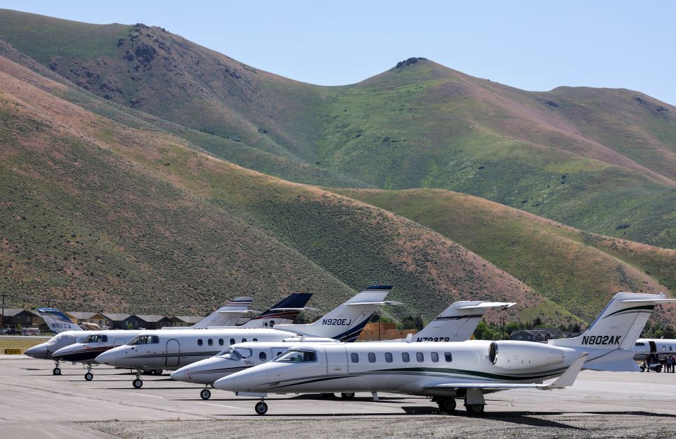 Private jets on airport tarmac with mountains in background