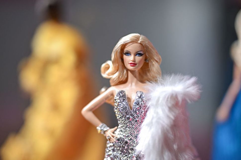 A Barbie doll dressed in a silver evening gown.