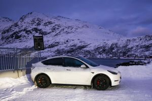 Tesla Model Y car is seen on a car parking covered by snow.