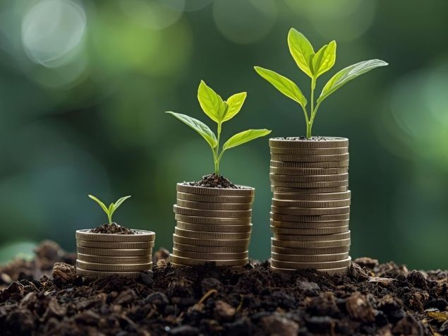 Three stacks of increasingly taller coins sitting on dirt with plant sprouts